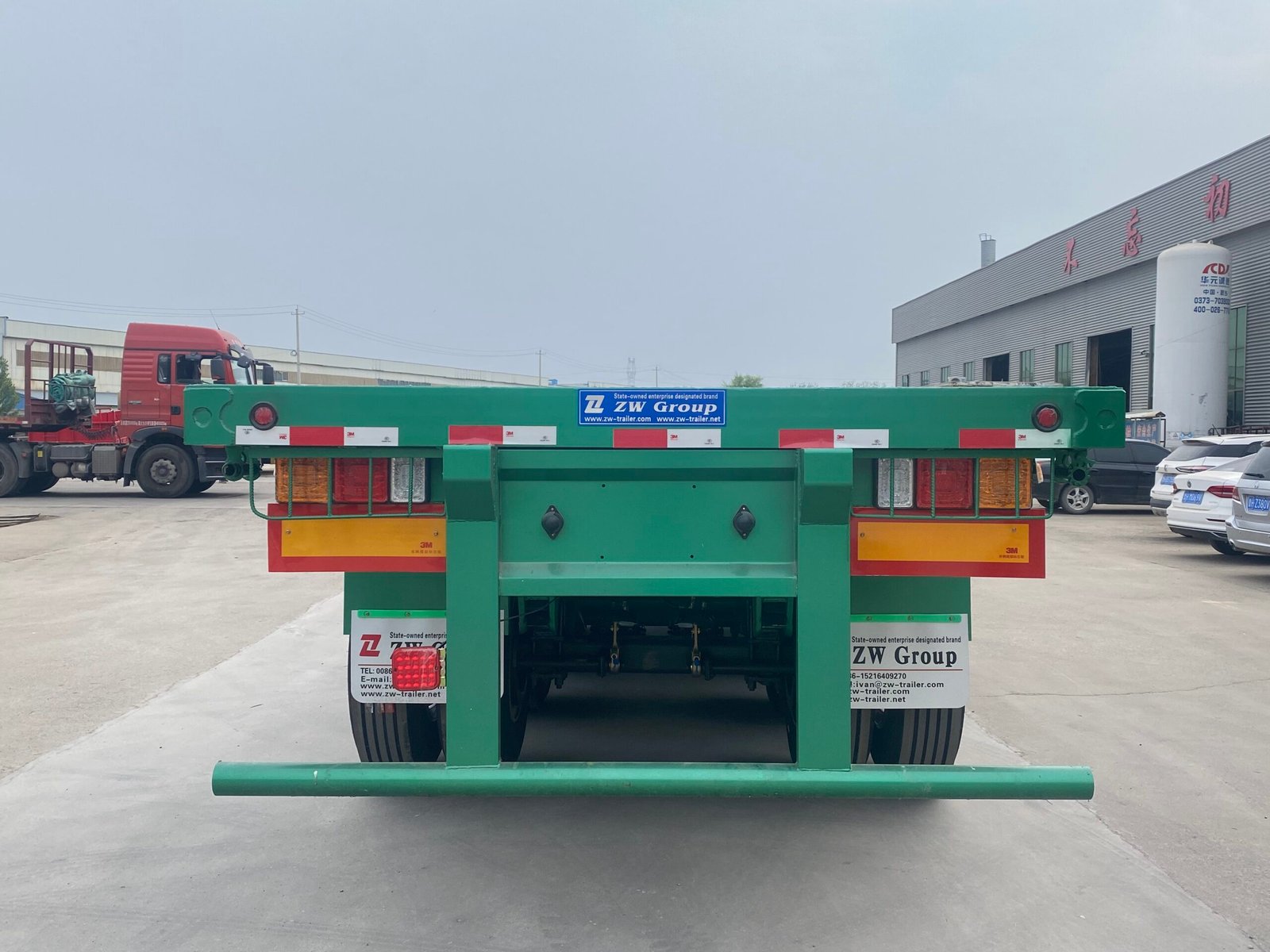 Rear view of ZW Group flatbed trailer with tail lights and twist locks