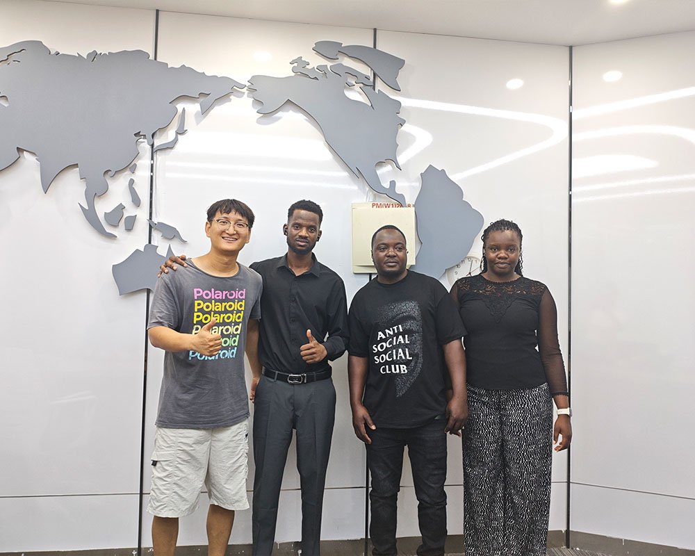 Three Zimbabwean clients touring the ZW Vehicle Group manufacturing plant in Liangshan, inspecting detachable gooseneck semi trailers.