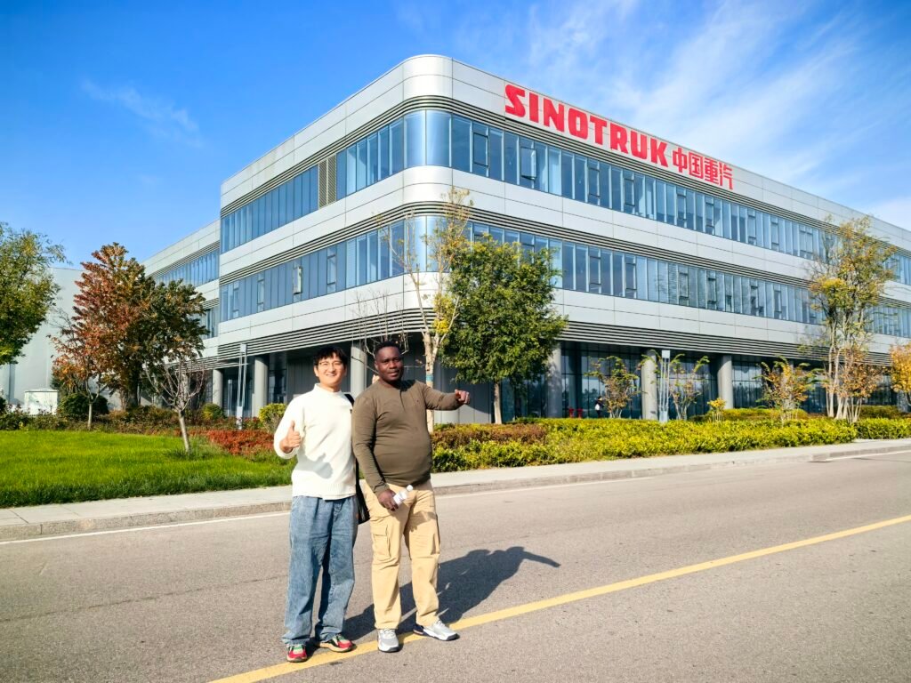 Congo clients touring the SINOTRUK factory in China, viewing HOWO trucks and flatbed trailer production